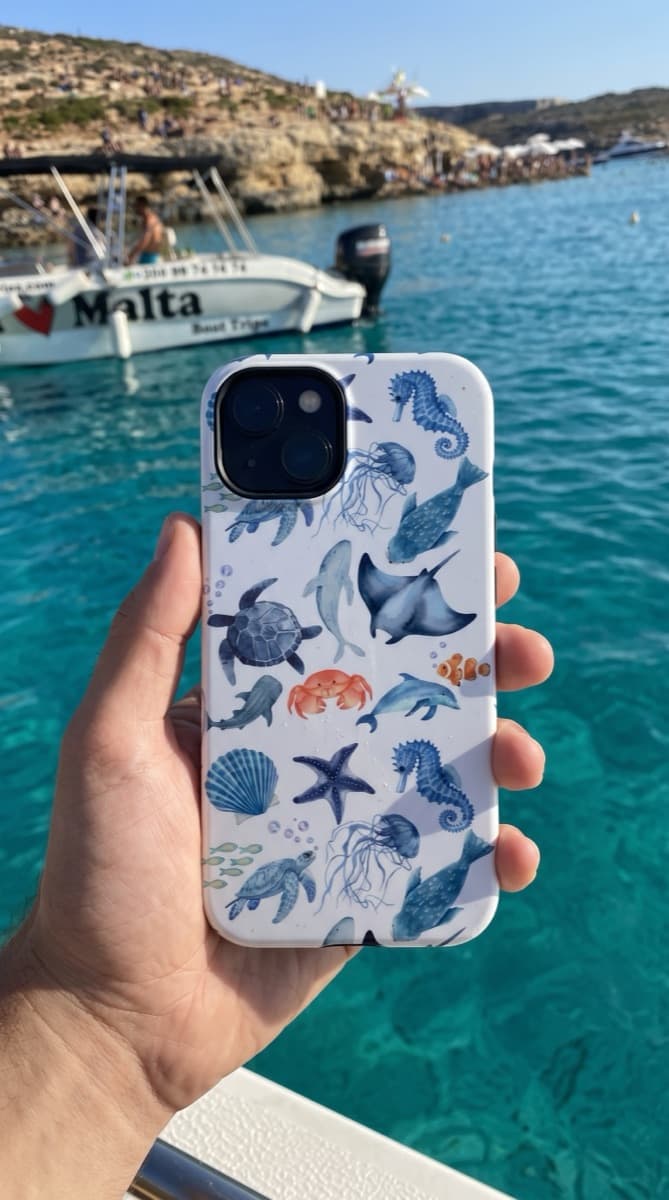 Sea-life pattern Avellé case held up over the water at the Blue Lagoon, Comino